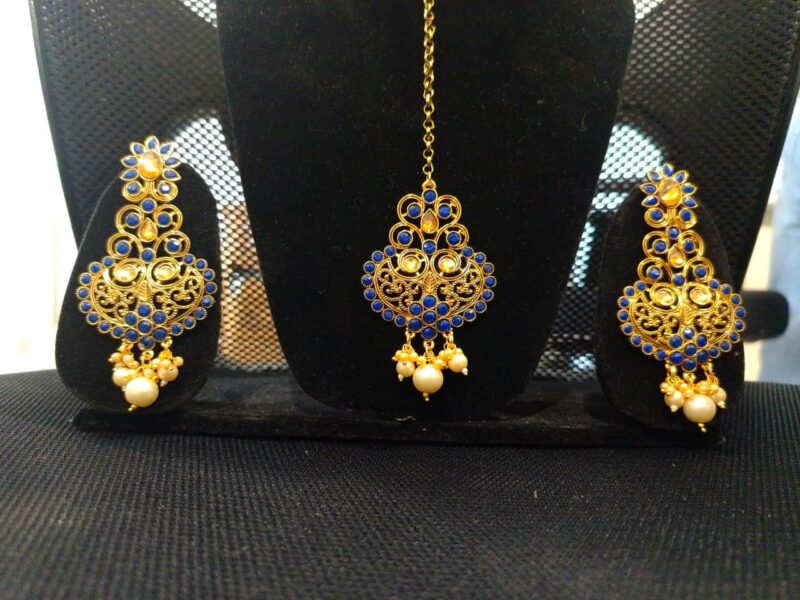 Indian Maang Tikka and Earrings featuring blue Kundan stones and pearls.